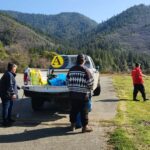 three people are standing next to a white truck