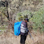 a person in standing in the middle a push while holding a bag