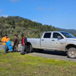 three people are standing next to a truck