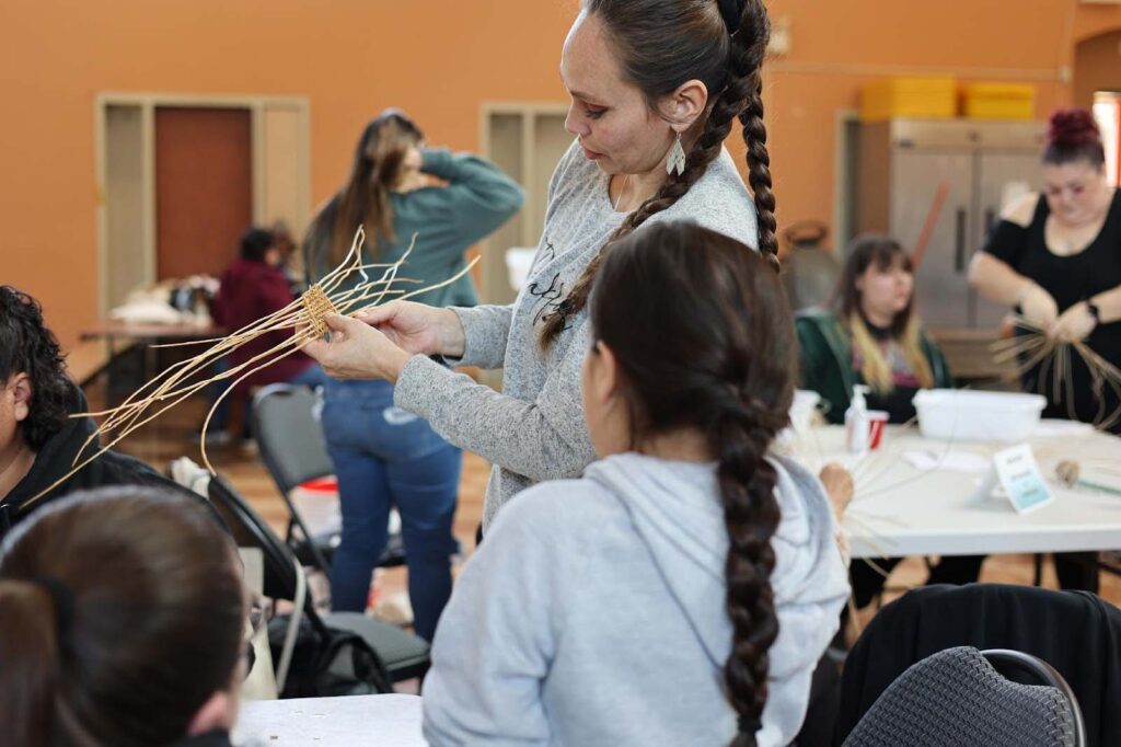 A person provides instruction on weaving baskets